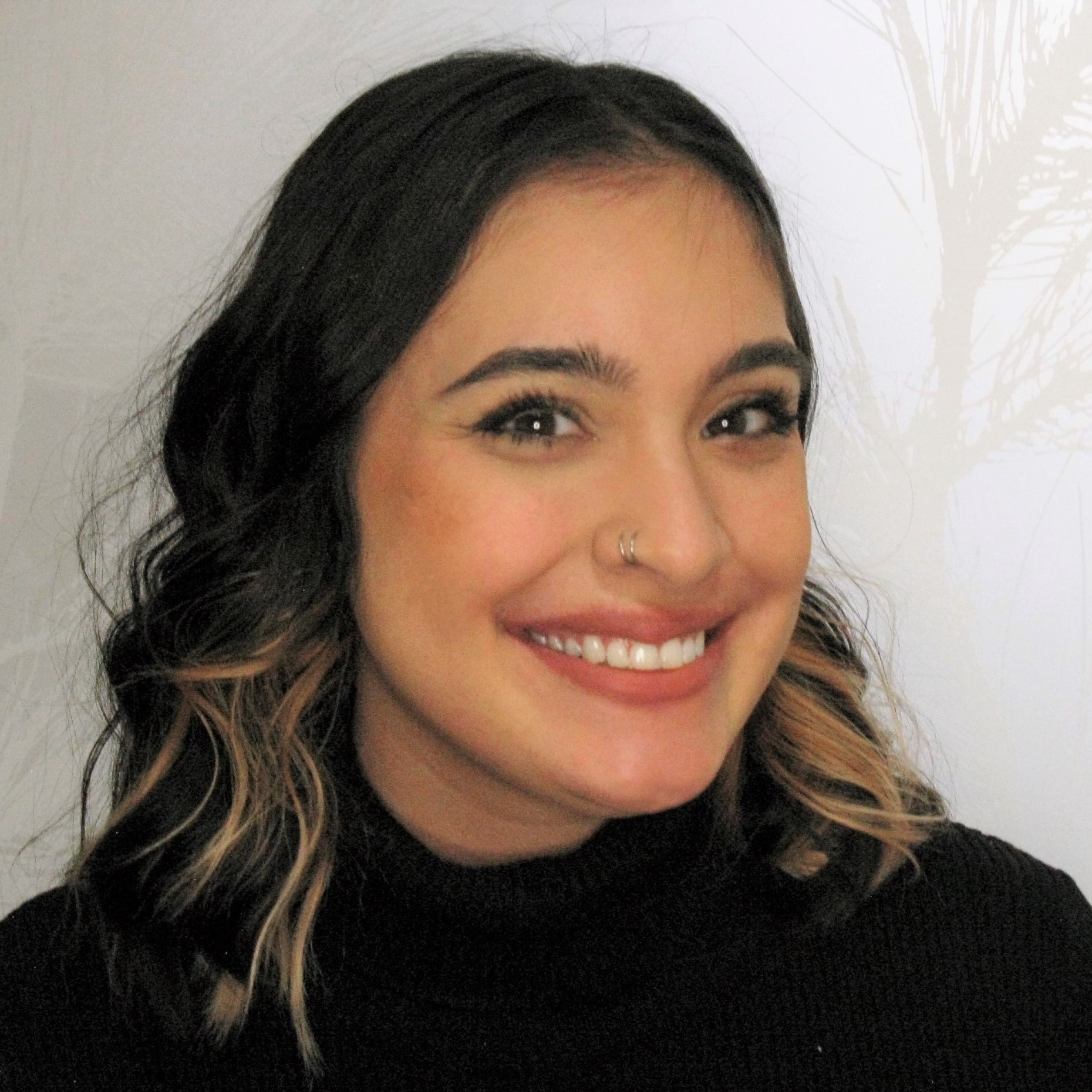 Woman smiling at camera in professional headshot against white background.